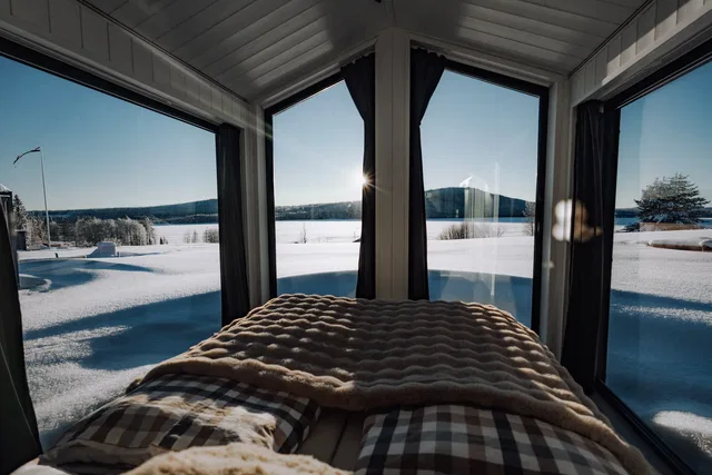 Bett im Chalet mit Blick auf die Winterlandschaft