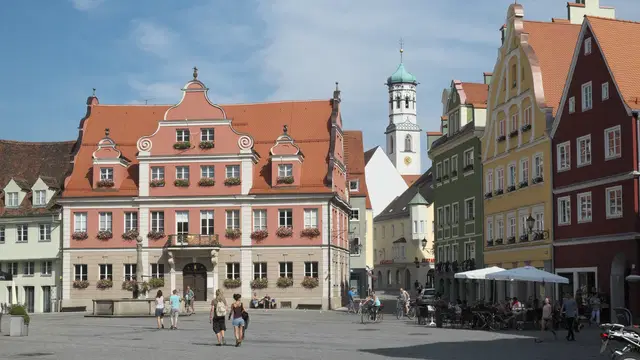 Historische Giebelhäuser am Memminger Marktplatz mit der Großzunft und einem Kirchturm im Hintergrund. Ortsmotiv zur Ausflugsplanung.