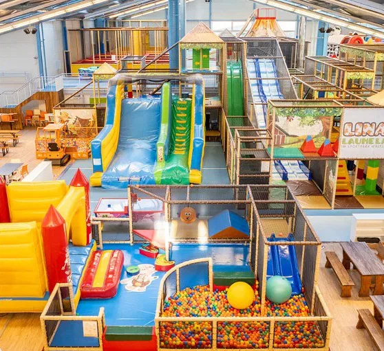 Großes Indoor-Spielparadies mit bunten Rutschen, Klettertürmen und Ballgrube