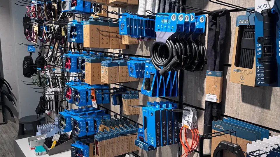 Regal mit blau verpacktem Elektronik- und Kabelzubehör, Kabeln und Kleinteilen im Shop.