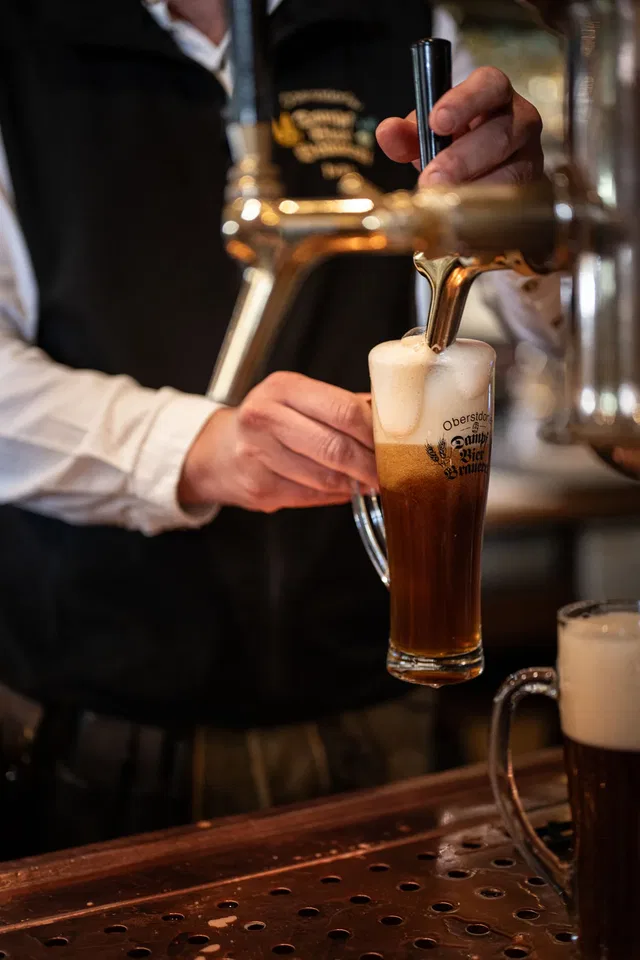 Bier wird aus dem Zapfhahn in ein Glas gezapft