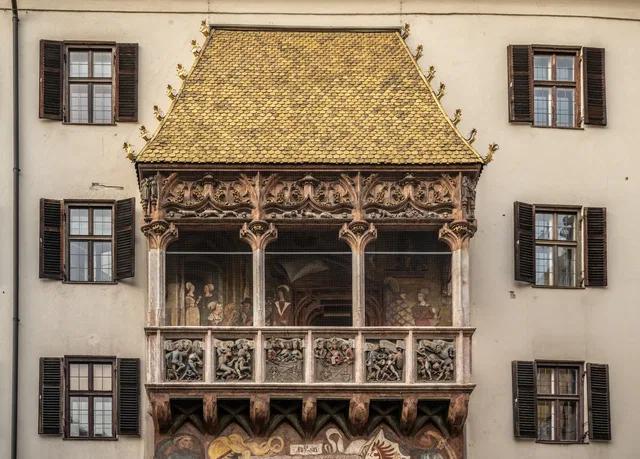 Reich verzierter historischer Erker mit goldenem Schindeldach und Reliefs